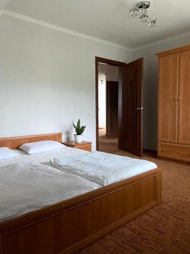 a bedroom with a large bed with a wooden frame at Вилла Поляна in Polyana