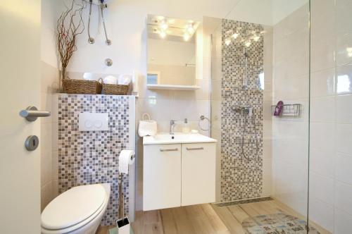 a bathroom with a toilet and a shower and a sink at Apartment Nena in Krk