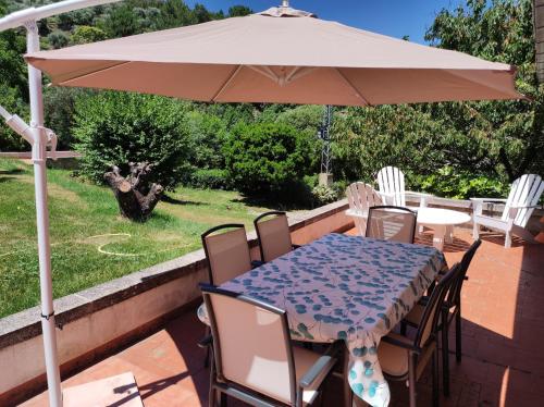 a table and chairs under an umbrella on a patio at Puente Canto de Gredos in Arenas de San Pedro