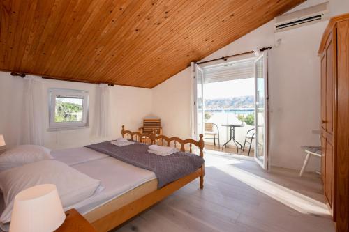 a bedroom with a bed with a wooden ceiling at Movo House in Pag