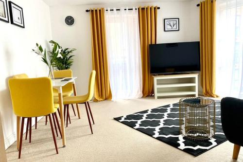 a living room with a tv and a table and chairs at Smartrips Apartments - Lakeside/Thurrock in West Thurrock