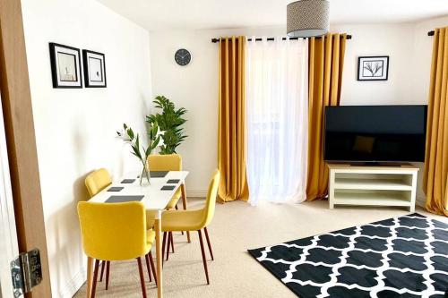 a living room with a dining table and yellow chairs at Smartrips Apartments - Lakeside/Thurrock in West Thurrock