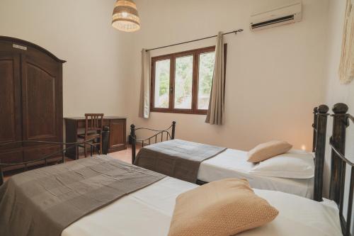 una camera con due letti e una finestra di Anima Hotel Sardinia a Fluminimaggiore