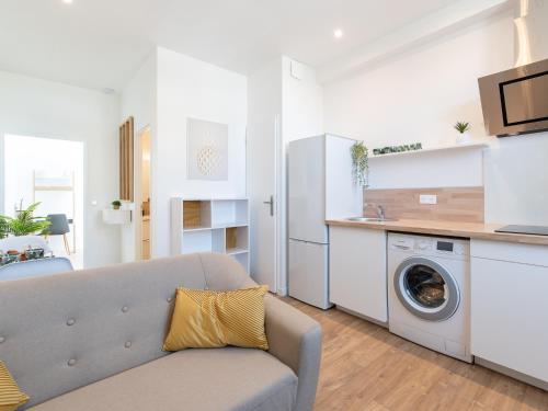 un salon avec un canapé et une machine à laver dans l'établissement Bourgoin T2 proche Gare Netflix Tout Confort, à Bourgoin-Jallieu