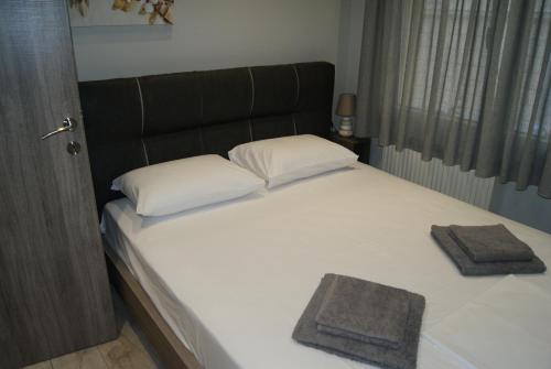 a bed with two white pillows and a black headboard at City Room in Volos