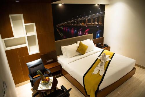 a hotel room with a bed and a table with a table at Hotel Namo Residency in Vijayawāda