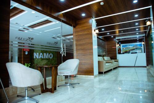a lobby with chairs and a table in a building at Hotel Namo Residency in Vijayawāda