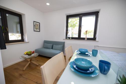 CASA Dersim في باد زاولغاو: غرفة معيشة مع طاولة وأطباق زرقاء عليها