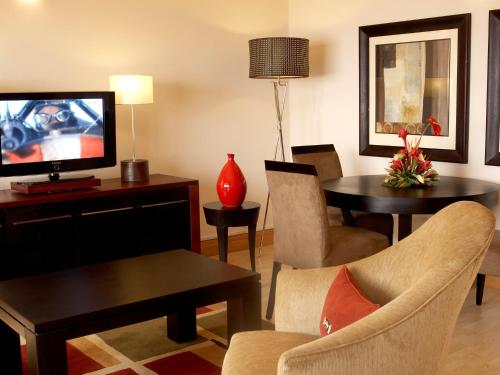 a living room with a television and a table and chairs at The Federal Palace Hotel and Casino in Lagos