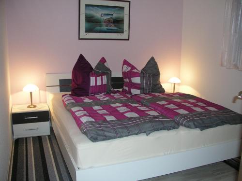 ein Schlafzimmer mit einem großen Bett mit lila Kissen in der Unterkunft Domizil Neu Venedig in Berlin