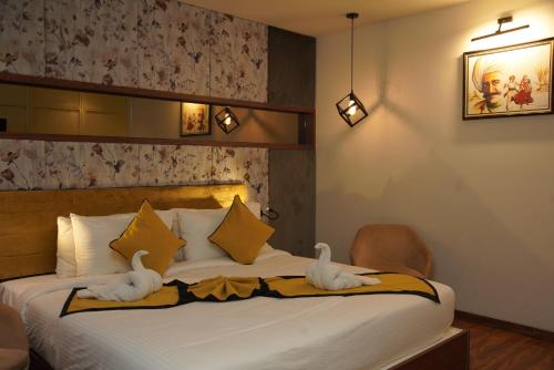 a bedroom with a bed with towels on it at Hotel Namo Residency in Vijayawāda