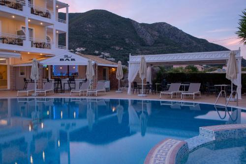 une piscine avec des chaises et un hôtel dans l'établissement Lefko Hotel & Apartments, à Nydri