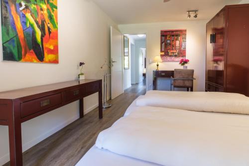 a bedroom with two beds and a desk and a painting at Haus Seidendorf in Sankt Kanzian
