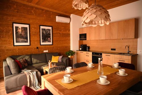 salon ze stołem i kanapą w obiekcie Apartamenty u Harrego BOUTIQUE SPA z klimatyzacja, balkon, sauna, tężnia parking w Kudowie Zdroju