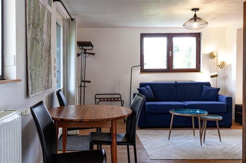 a living room with a blue couch and a table at Le Tintinnabule in Villard-de-Lans