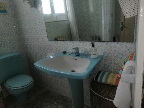 a bathroom with a sink and a toilet and a mirror at La Casa de Colores in Sariego