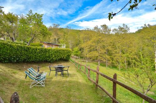 a table and chairs in a yard next to a fence at Agriturismo Vezzano in Chiusi della Verna
