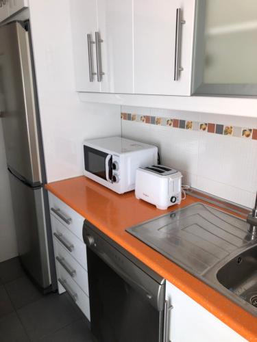 a kitchen with a counter with a toaster and a microwave at Mar Azul in Chiclana de la Frontera