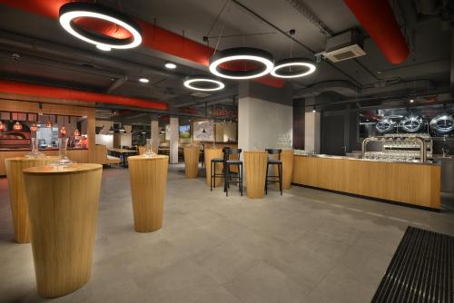 a restaurant with wooden bar stools and a kitchen at Hotel Element in Lipno nad Vltavou