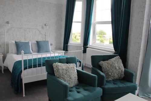 イーストボーンにあるBeamsley Lodge B&Bのベッドルーム1室(ベッド1台、椅子2脚付)