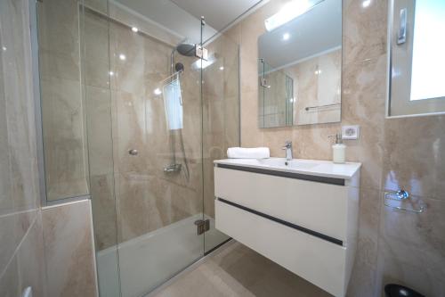 W łazience znajduje się prysznic, umywalka i lustro. w obiekcie Alma City Center Apartment's w Heraklionie