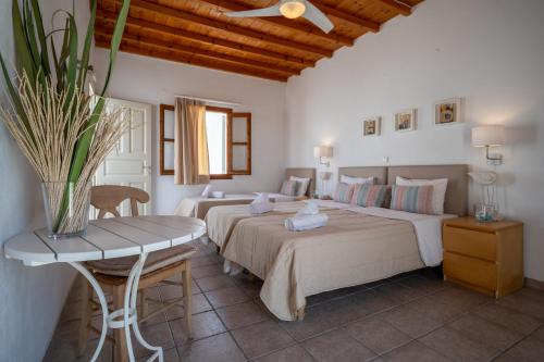 ein Schlafzimmer mit zwei Betten und einem Tisch mit einer Vase in der Unterkunft Twins Apartments By Mina in Ornos