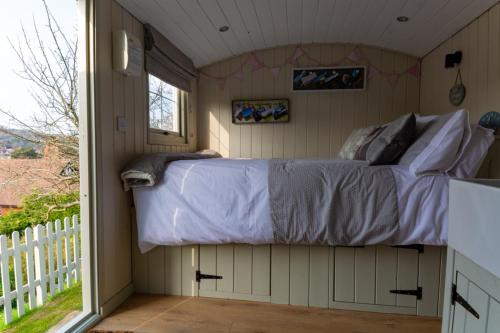 a bed in a room with a window at Hilltop Hut in Church Stretton
