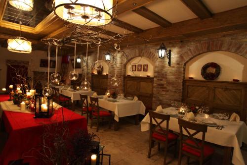 a restaurant with white tables and chairs and a chandelier at Dworek Rajska Góra in Wejherowo