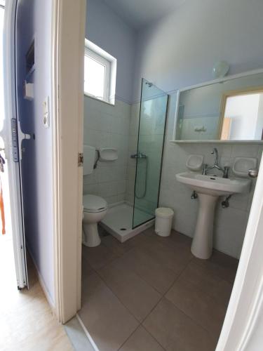 a bathroom with a toilet and a sink and a shower at Rivulet Studios in Laganas