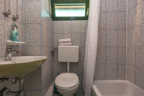 a small bathroom with a toilet and a sink at Mini stone house in Omiš