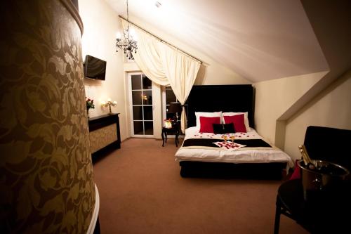 a bedroom with a large bed with red pillows at Dworek Rajska Góra in Wejherowo