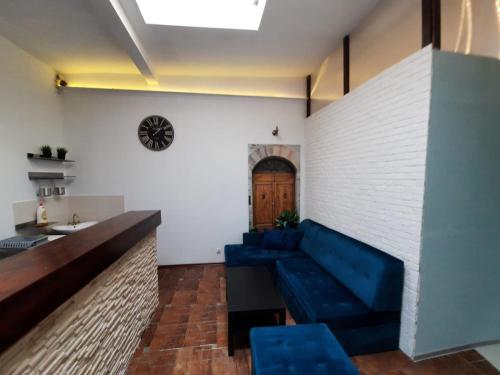 - un salon avec un canapé bleu et un mur en briques dans l'établissement Przytulny loft 5 min od centrum Gdańska, à Gdańsk