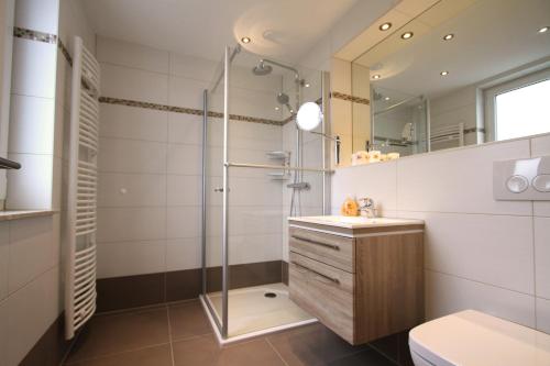ein Bad mit einer Dusche, einem Waschbecken und einem WC in der Unterkunft Die Bleibe in Ahlbeck