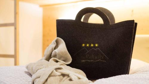 a black bag sitting on top of a bed at Appartements Pohuibe in Anterselva di Mezzo