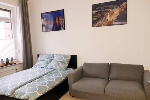 1 dormitorio con sofá, cama y silla en Apartment in Neudorf Nahe DU Zentrum und Uni/Zoo, en Duisburg