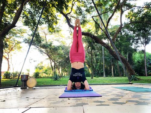 a woman doing a handstand in a park at Gaia Hospedagem Holística in Brotas