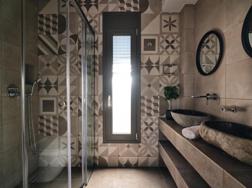 a bathroom with two sinks and a glass shower at LaLune SeaSide Villa, Zante Zen By ThinkVilla in Kipseli