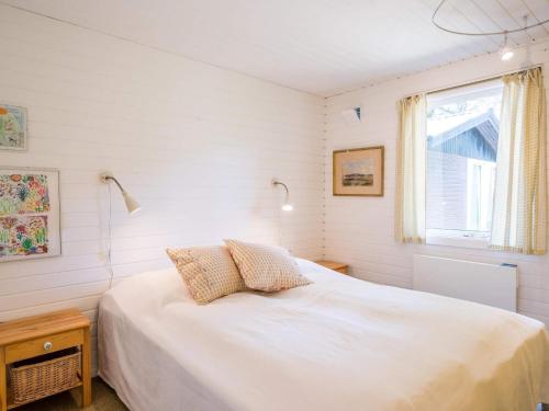 Un dormitorio con una cama blanca y una ventana. en 5 person holiday home in Nørre Nebel, en Nørre Nebel