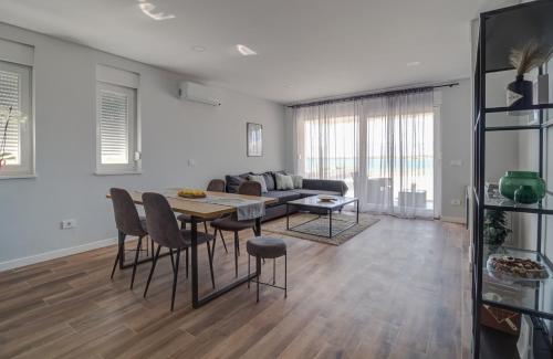 ein Wohnzimmer mit einem Tisch, Stühlen und einem Sofa in der Unterkunft B & R Summer breeze apartments in Nin