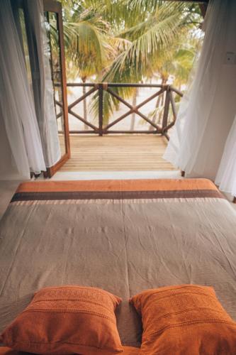 a bed with two pillows on it in a room at Casa Kuaa in Brisas de Zicatela