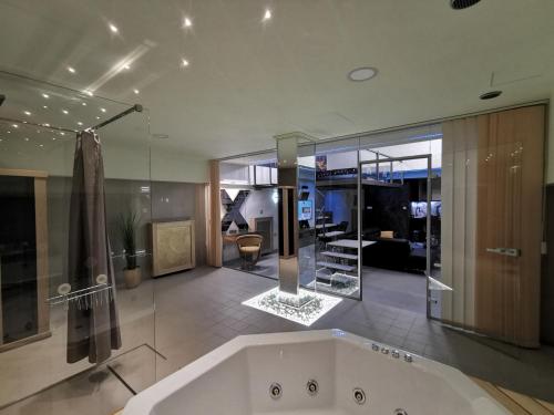 baño grande con bañera y paredes de cristal. en XSpa Apartment cryptocurrency pay available en Novi Sad