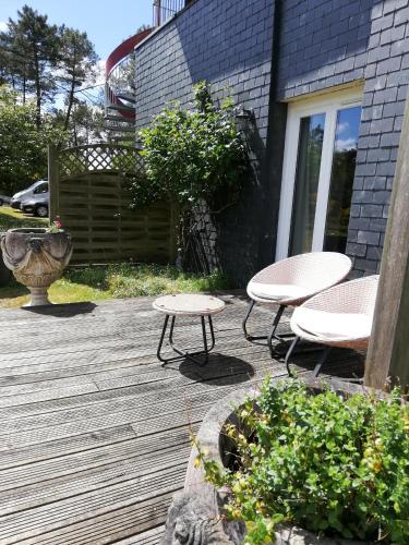 a patio with two tables and two chairs on a deck at Le Clos du Chêne in Langon