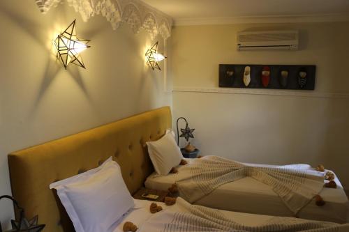 a bedroom with two beds and stars on the wall at Dar Andamaure in Marrakech