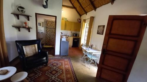 a living room with a table and a kitchen at 41 Ridge- self catering cottages in Midrand