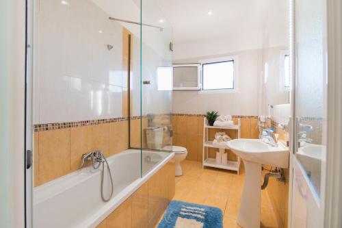 a bathroom with a tub and a sink and a toilet at Villa PANGALIS Romantica in Kato Pavliana
