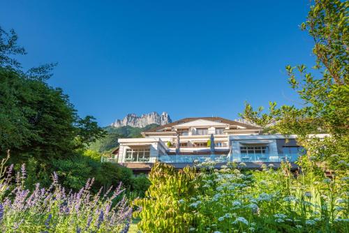 a large building with a mountain in the background at Hôtel Beau Site Talloires B SPA in Talloires