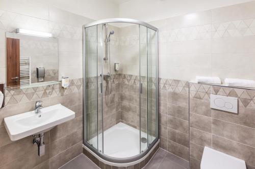 a bathroom with a shower and a sink at Graphic Hotel in Nový Jičín