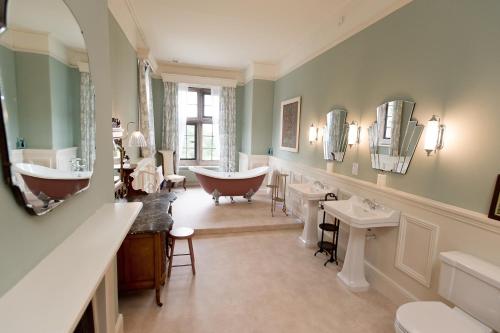 a bathroom with two sinks and a bath tub at Burton Court in Dilwyn