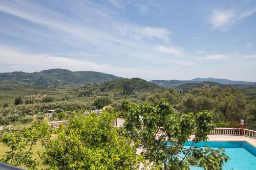 a view of a pool with mountains in the background at Villa PANGALIS Romantica in Kato Pavliana