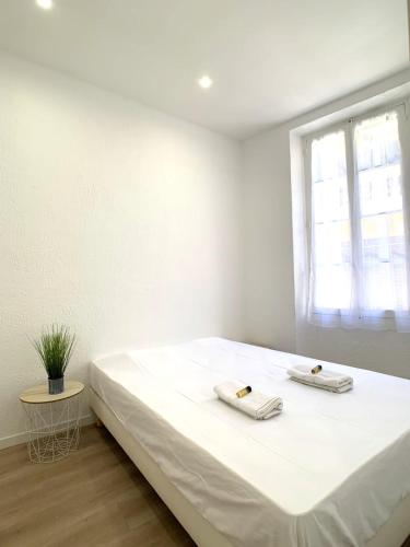 un lit blanc dans une chambre avec une fenêtre dans l'établissement Renovated apartment AC - wifi - 2-4pers - Center Antibes rue James Close, à Antibes